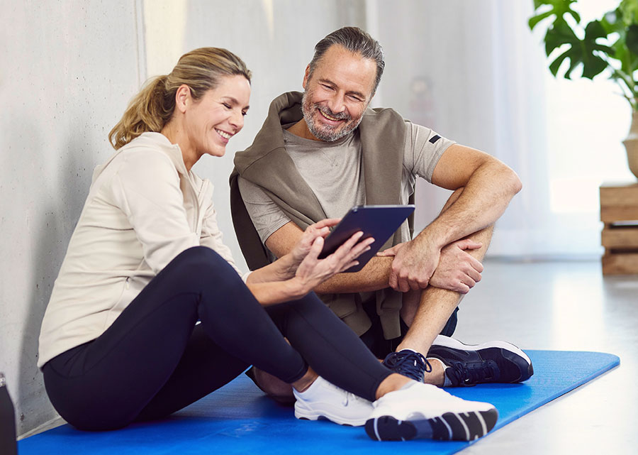 Mann und Frau schauen auf ein Tablet.
